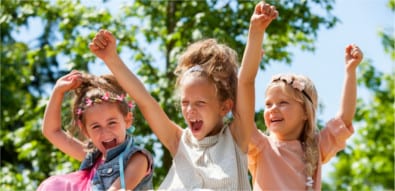 happy young girls raising hands together in park. happy young girls raising hands together in park.